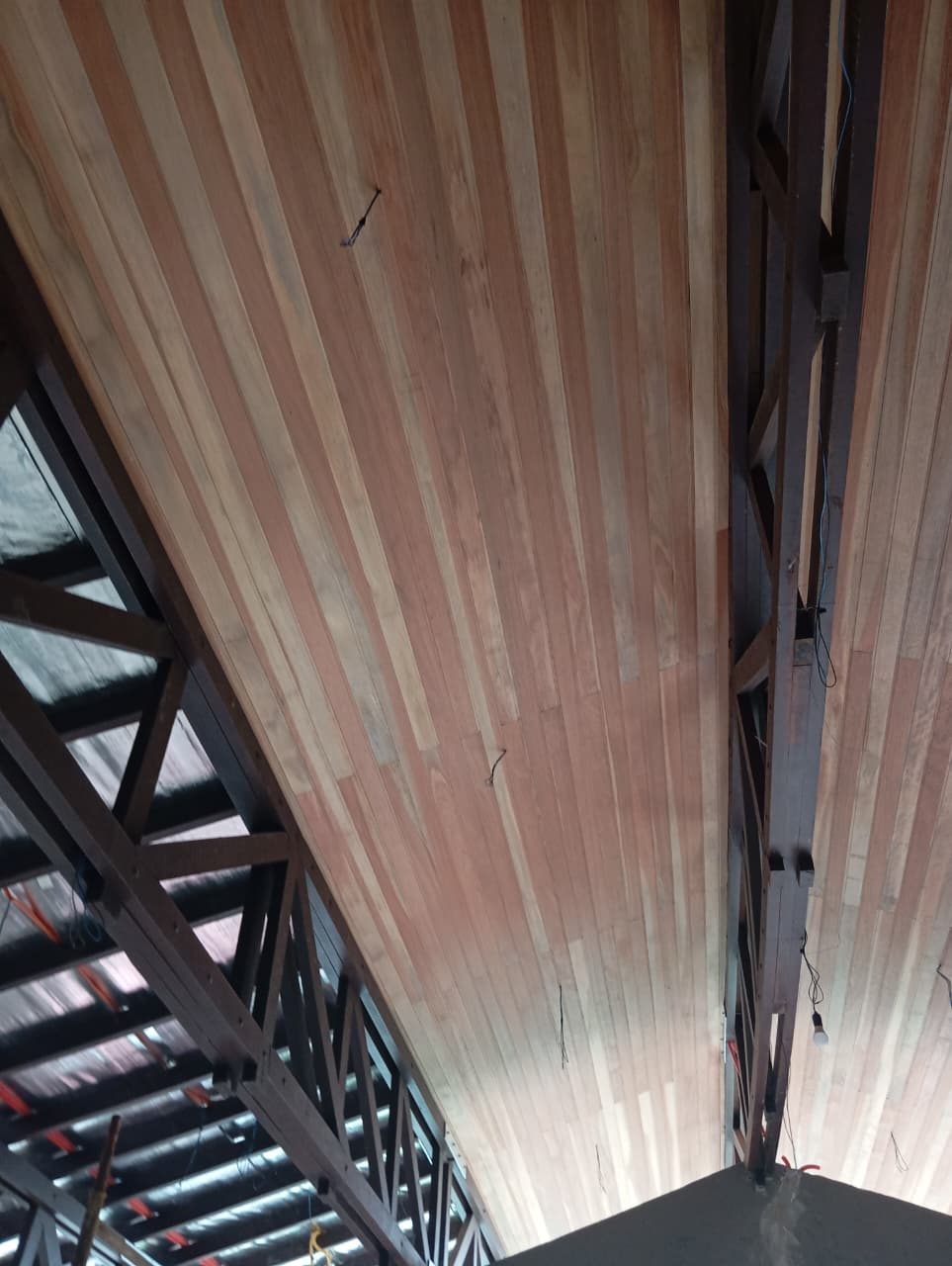 Detalhe do forro de madeira entre estruturas metálicas