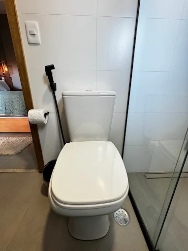 Detalhe dos revestimentos claros e da área sanitária de um banheiro do Palulu Flat