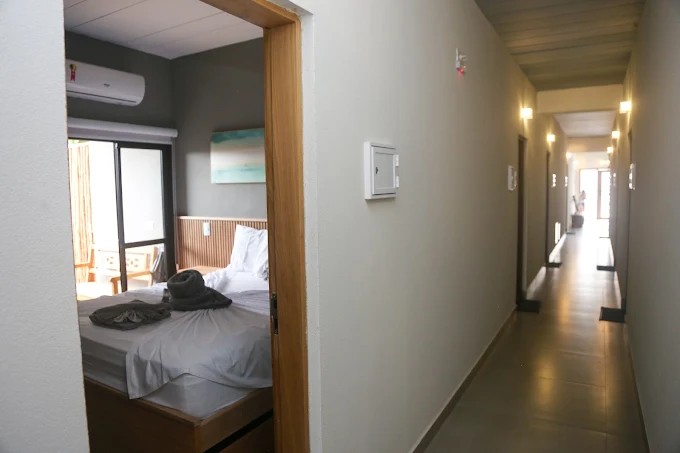Corredor interno do Palulu Flat com iluminação de teto e acessos às unidades