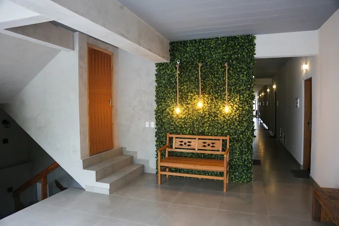Hall de entrada e recepção do Palulu Flat com piso claro, escadas e parede verde