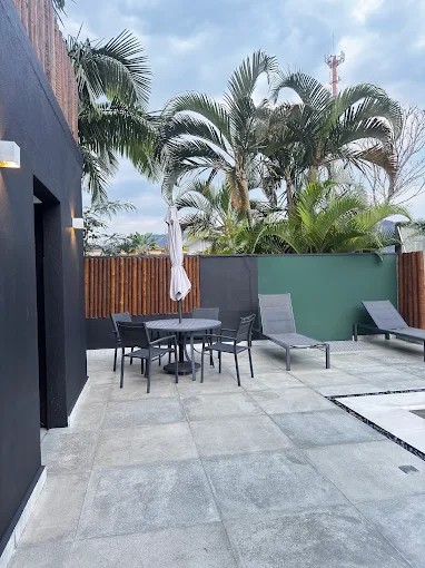 Pátio de lazer do Palulu Flat com piso externo, vegetação e área de convivência