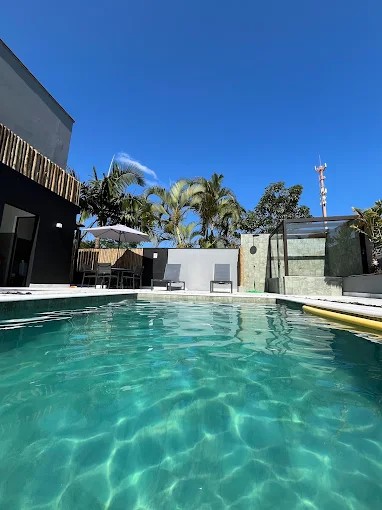 Vista da água da piscina e da área externa do Palulu Flat em Juquehy