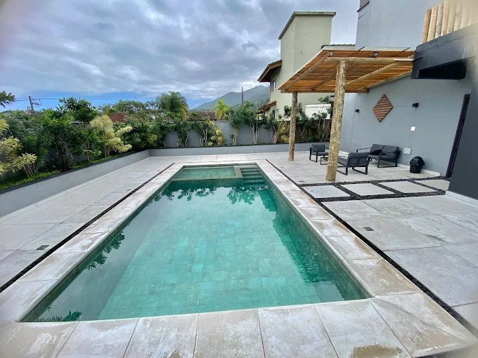 Vista ampla da piscina do Palulu Flat, do piso do entorno e do pergolado
