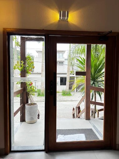 Porta de entrada do Palulu Flat vista de dentro, com acesso à escadaria externa