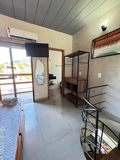 Ambiente de hospedagem do Palulu Flat com piso revestido e porta de acesso à área externa