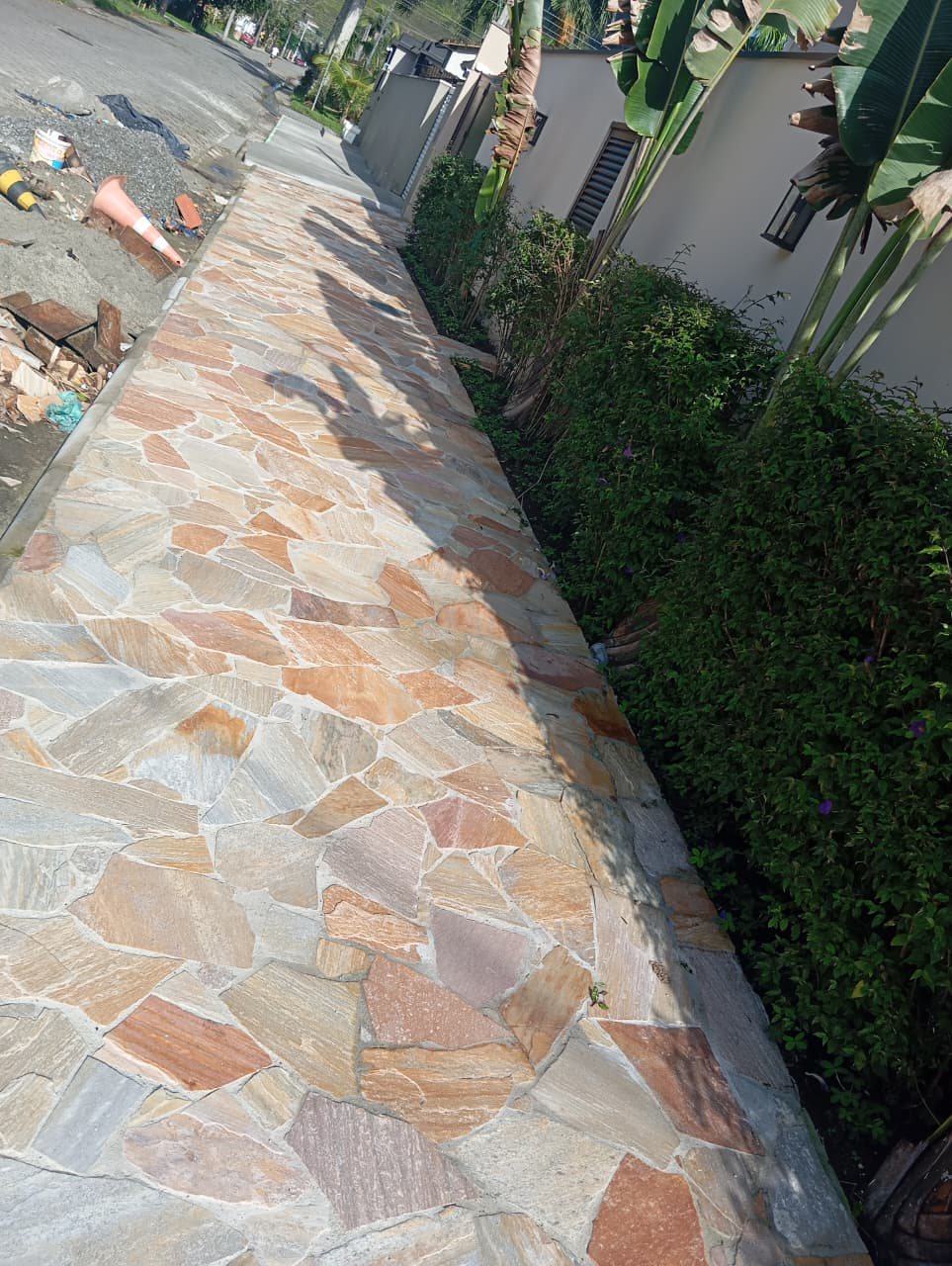 Calçada com assentamento de pedras junto à residência