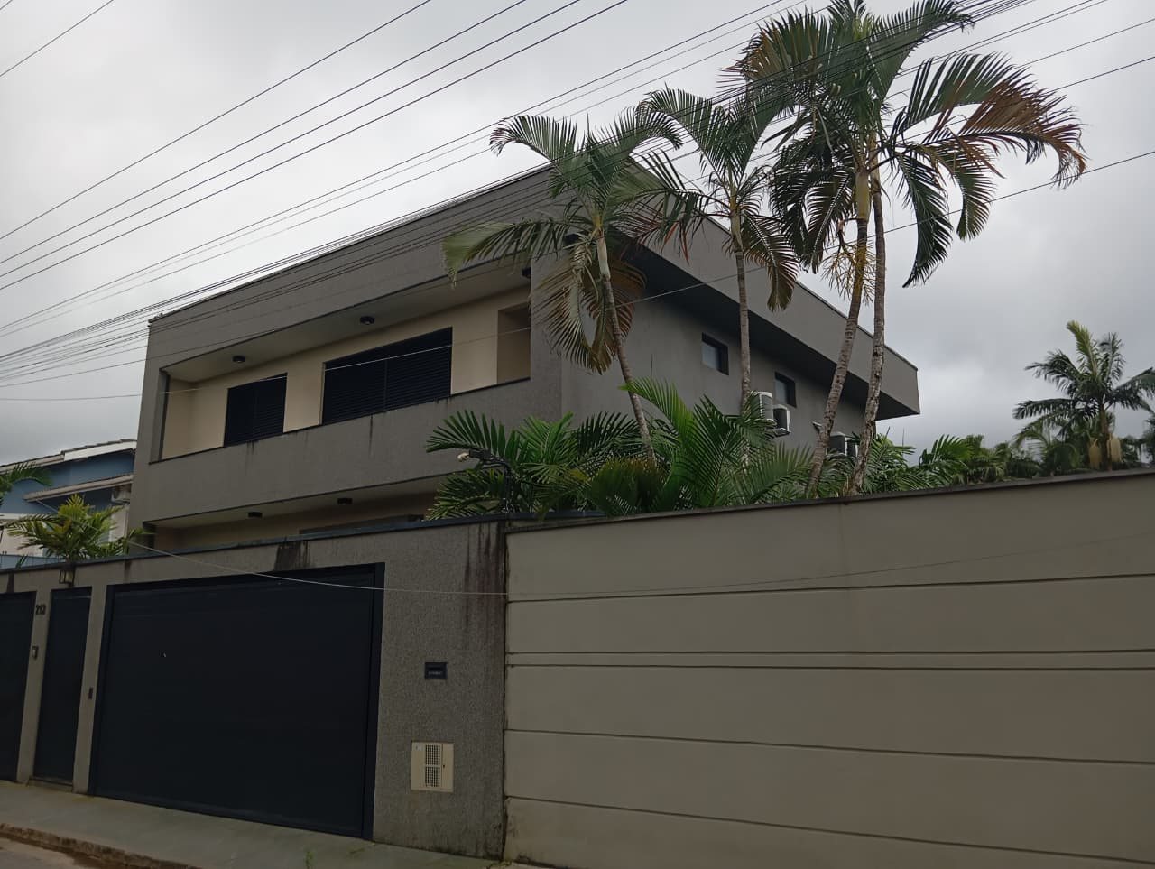 Residência em Juquehy com varanda no pavimento superior e fachada em tons neutros